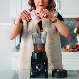 Woman using a blender in her kitchen