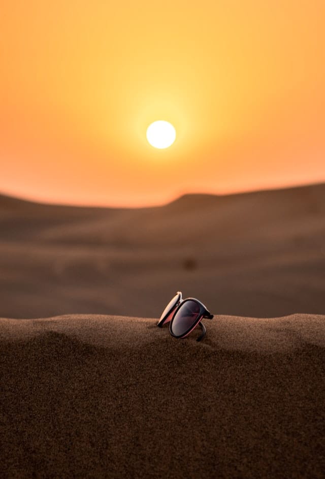 sun glasses on a dune in the desert