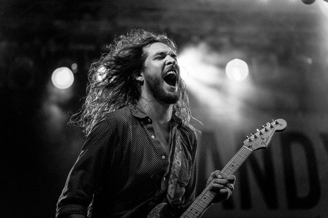 Musician playing guitar on stage