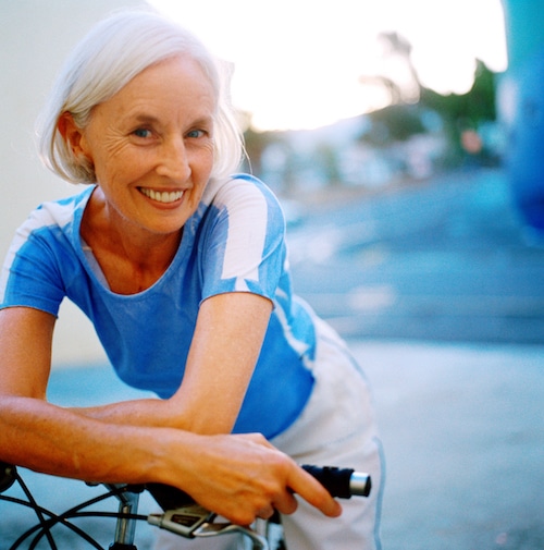 elderly person happily riding a bike 