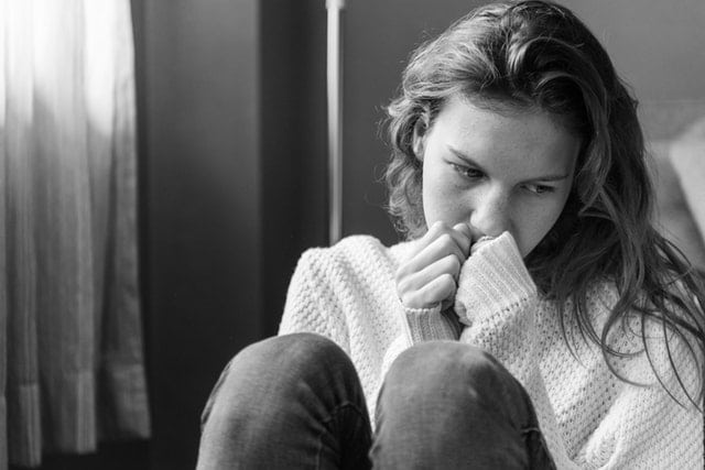 sad girl leaning against a wall