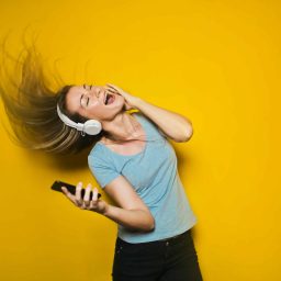 woman listening to music in headphones while whipping her hair back and forth