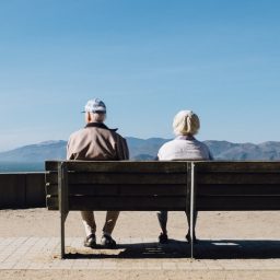 Couple sitting together on a bench.