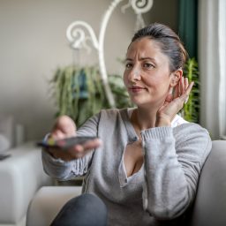 Woman with hearing aid watching television