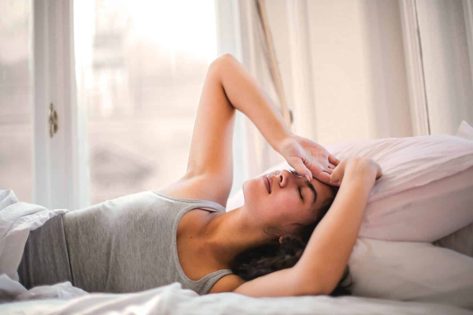 Woman in bed struggling to sleep.