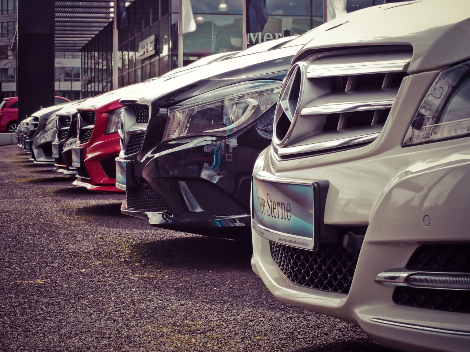 A row of cars sitting at a lot.