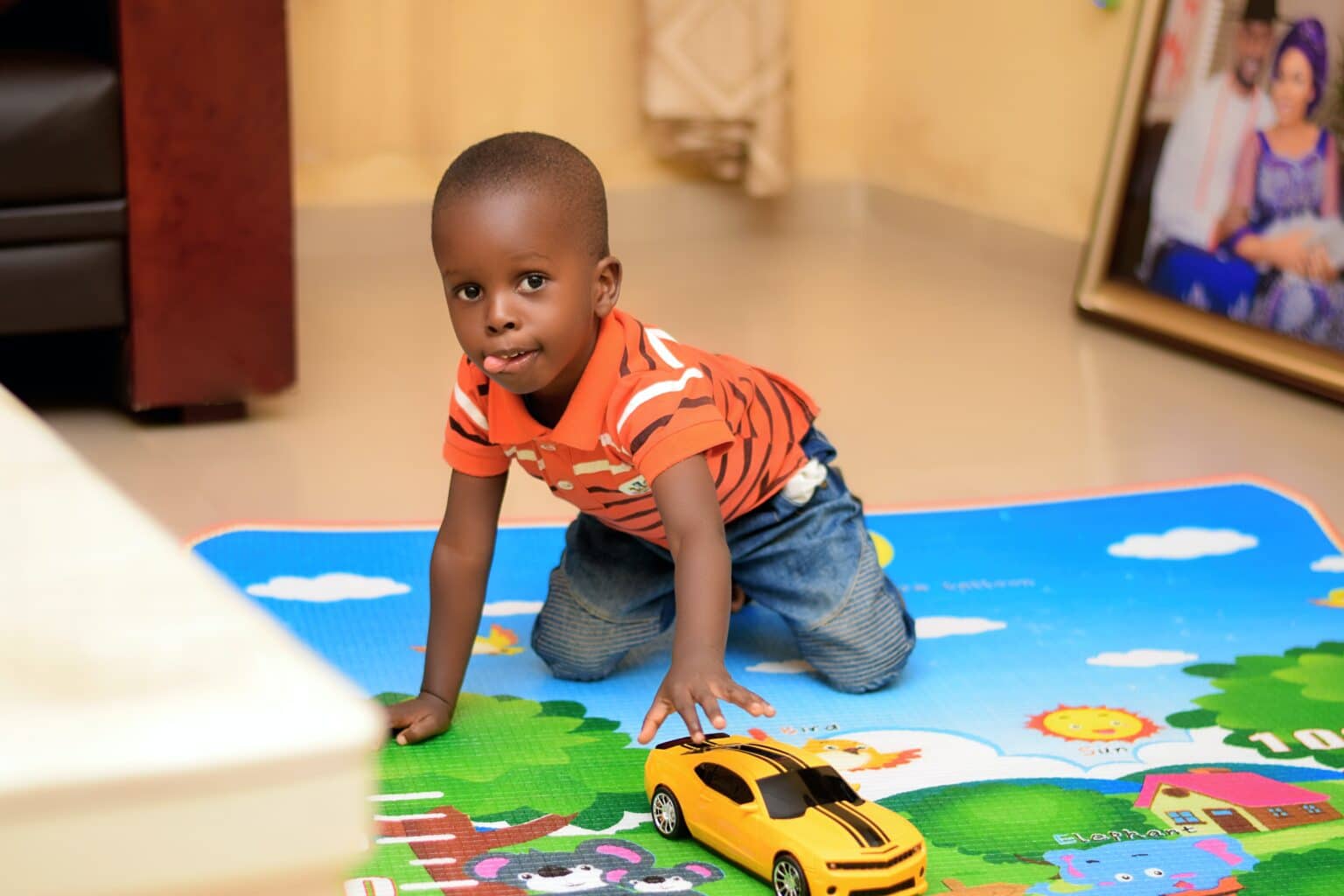 Little boy playing on a mat at daycare.