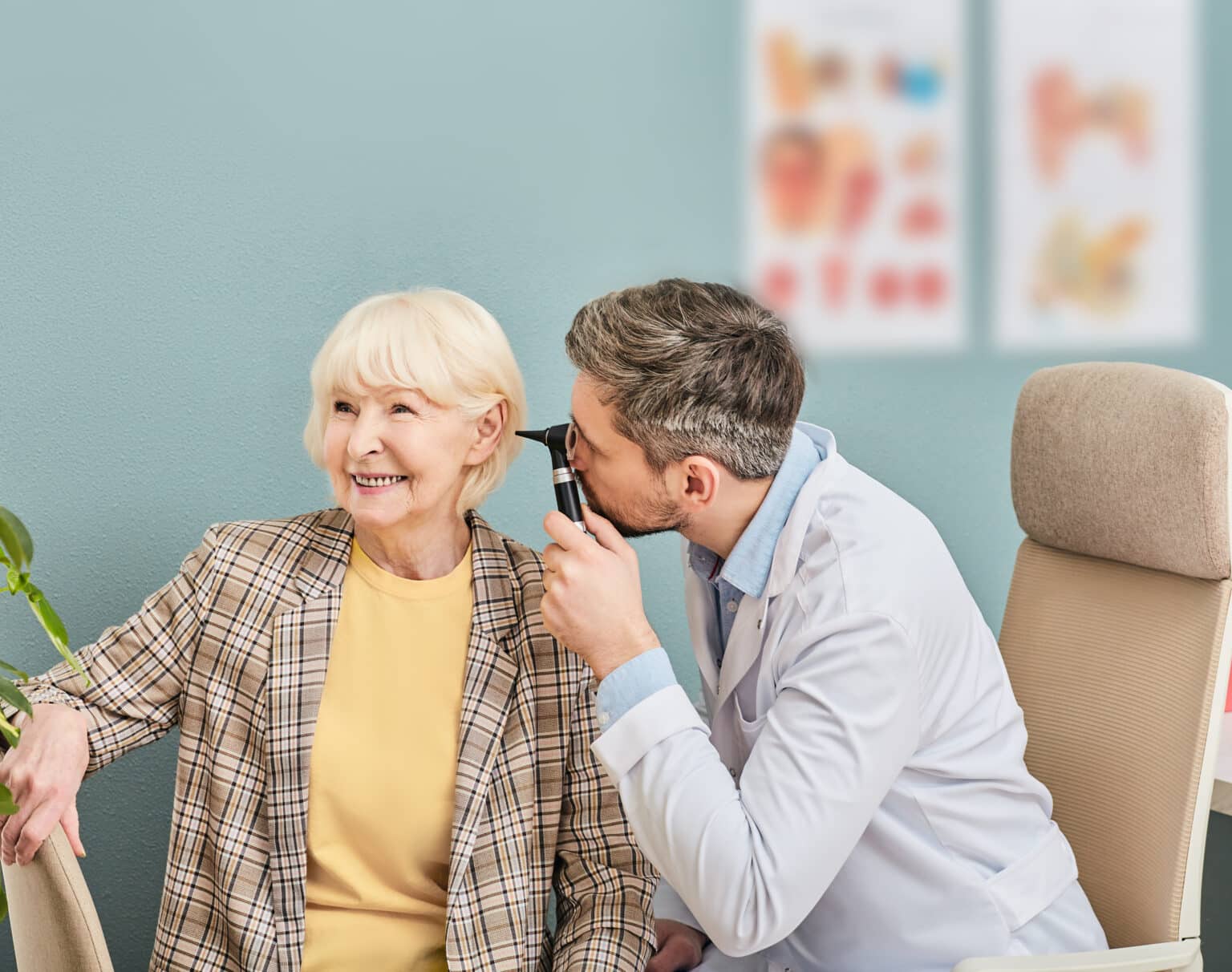 Smiling senior woman receiving an ear exam.