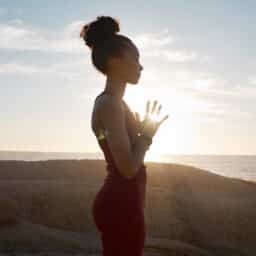 Woman does yoga pose at sunset