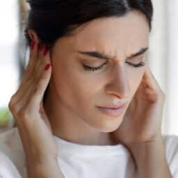 Woman with hyperacusis holding her ears