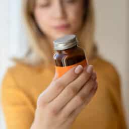 Woman holding supplement bottle