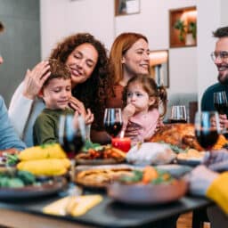 Happy extended family celebrating Thanksgiving at dining table